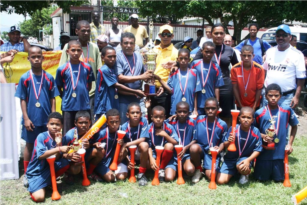 Nicandro Pérez en nombre de la Cervecería Nacional Dominicana entrega el trofeo de campeón a la Asociación de Fútbol de la Provincia Santo Domingo (ASOFUTSADO), del torneo de Fútbol Infantil Padre Vicente